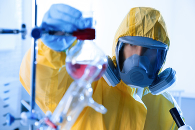 Scientist in chemical protective suit working at laboratory. Virus research