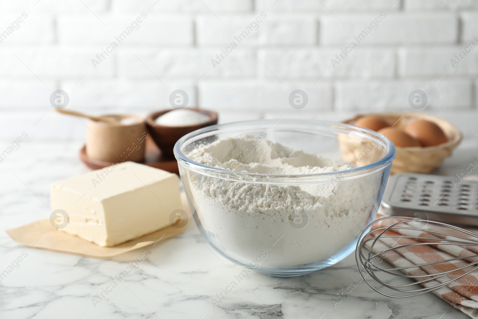 Photo of Making shortcrust pastry. Different ingredients for dough and whisk on white marble table