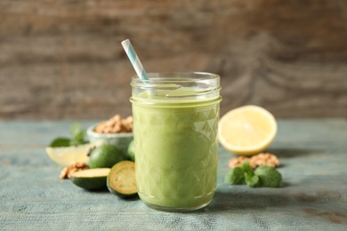 Photo of Fresh feijoa smoothie in glass on wooden table, closeup