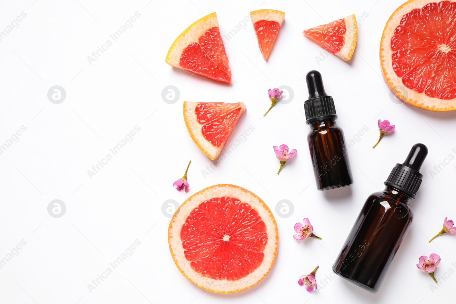 Photo of Flat lay composition with bottles of citrus essential oil on white background. Space for text