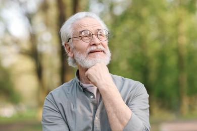 Portrait of happy grandpa with glasses in park