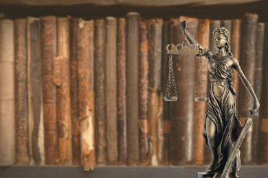 Image of Law and wisdom. Statue of Lady Justice near shelf with books, space for text