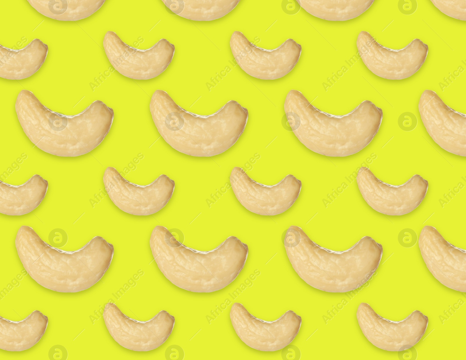 Image of Many tasty cashew nuts on yellow background, flat lay