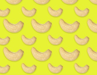 Many tasty cashew nuts on yellow background, flat lay