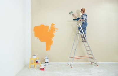 Photo of Woman painting wall indoors, space for text. Home repair