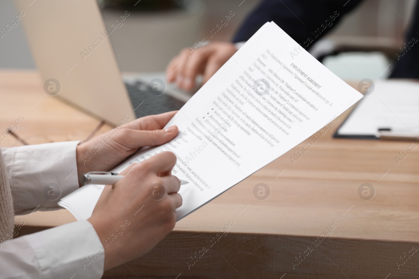 Photo of Woman signing employment agreement at table in office, closeup. Work contract