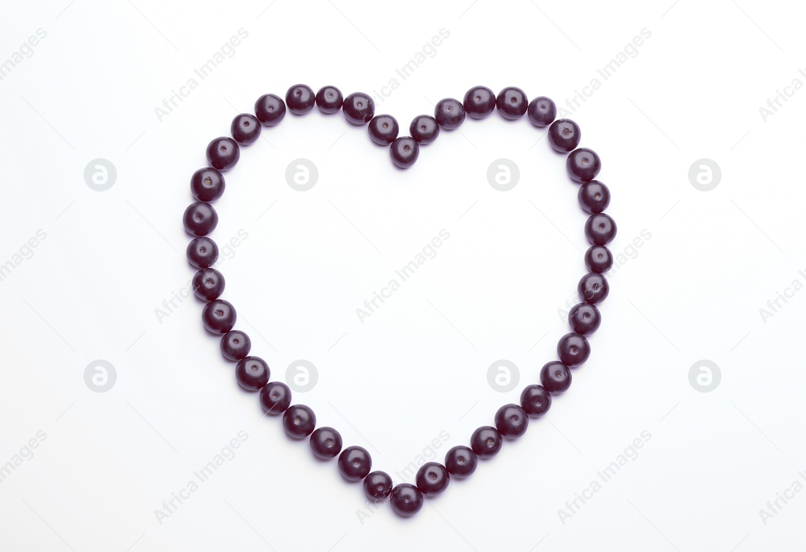 Photo of Heart made of fresh acai berries on white background, top view