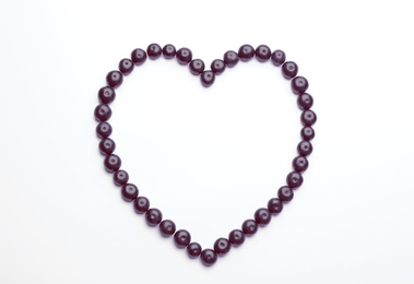 Heart made of fresh acai berries on white background, top view
