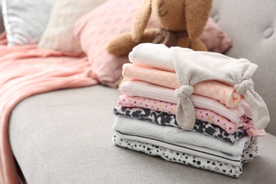 Photo of Stack of stylish child clothes on sofa