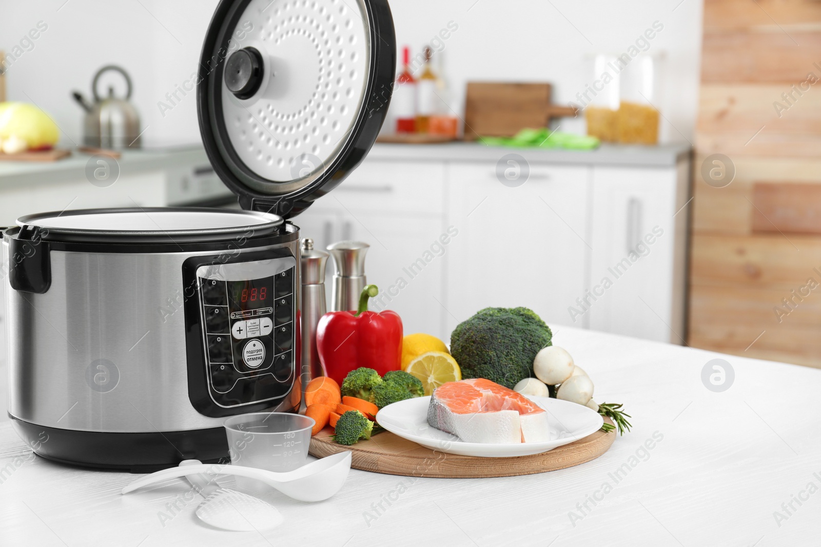 Photo of Modern multi cooker and products on kitchen table