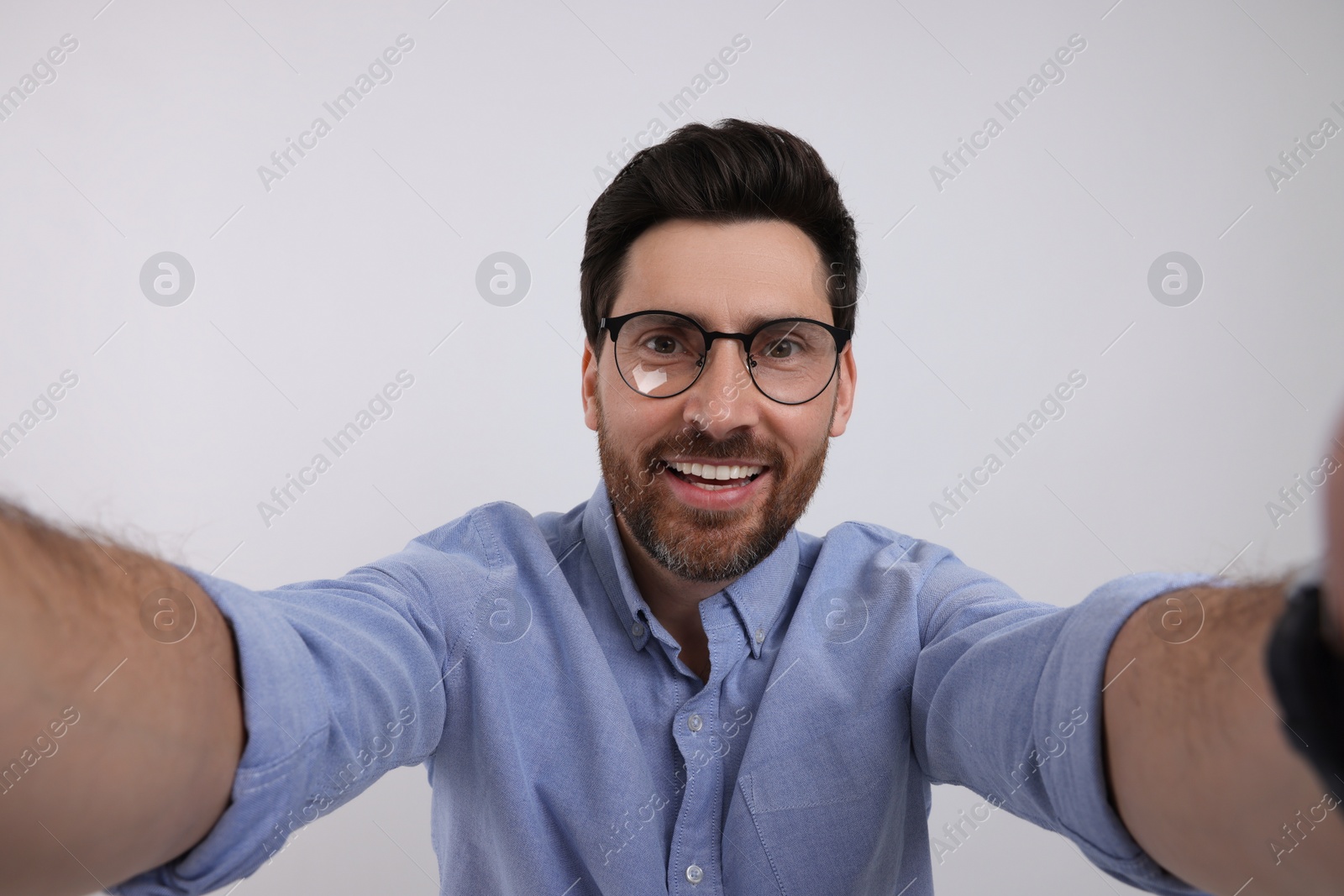 Photo of Smiling man taking selfie on white background