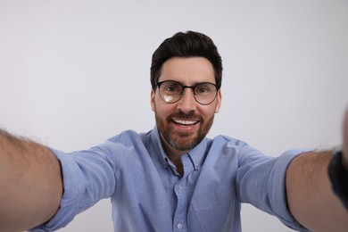 Photo of Smiling man taking selfie on white background