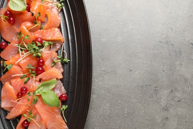 Photo of Delicious salmon carpaccio served on grey table, top view. Space for text