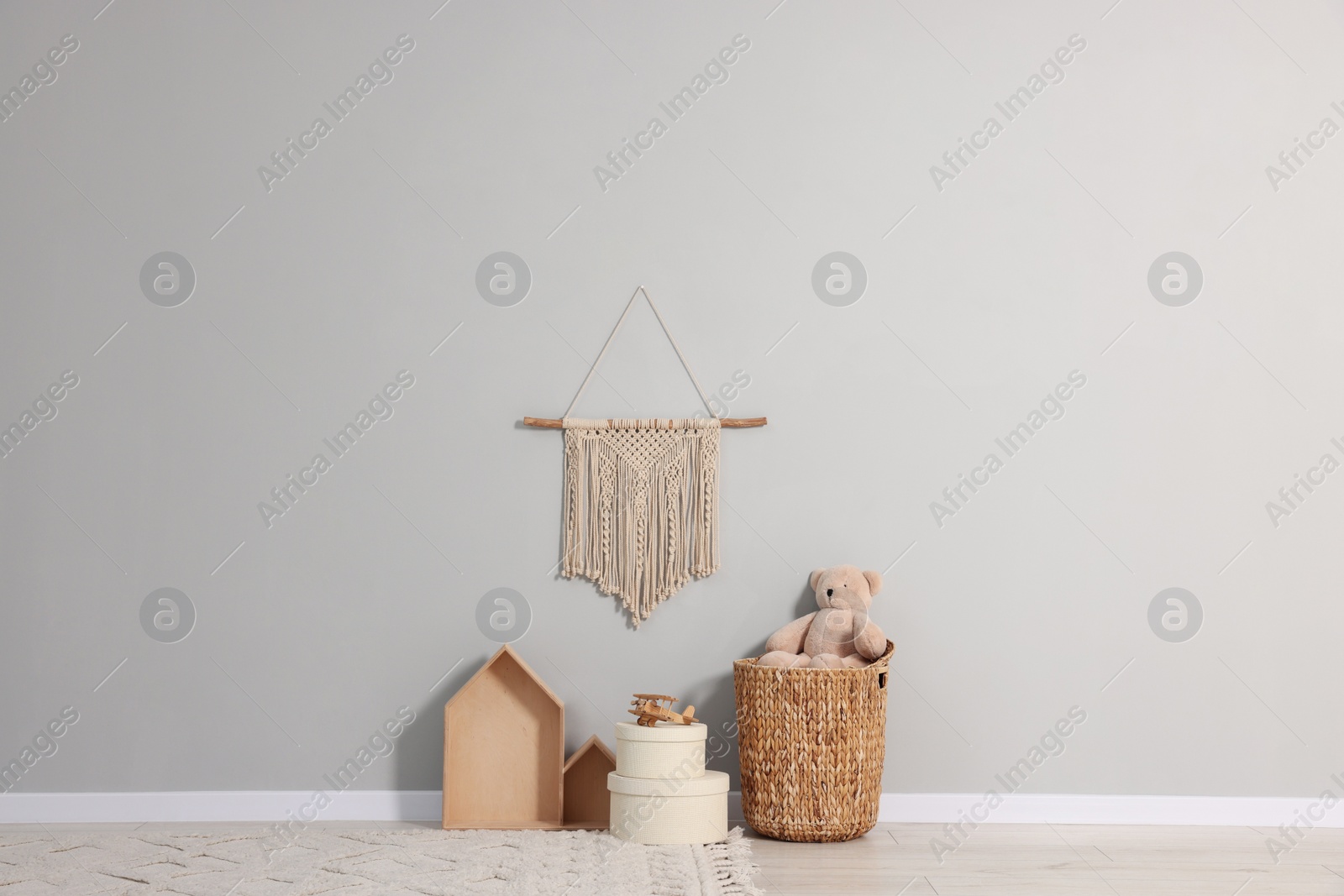Photo of Beautiful children's room with grey wall, decor elements and toys. Interior design