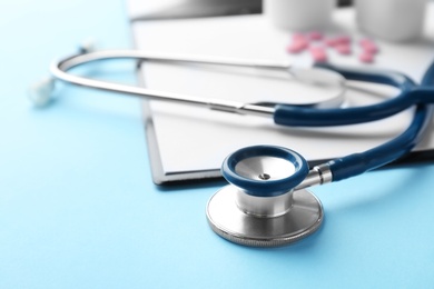 Photo of Stethoscope and clipboard on color background, closeup. Medical equipment