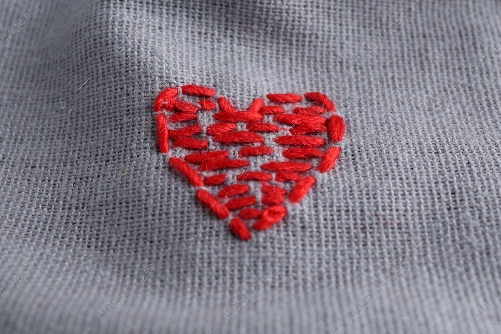 Photo of Embroidered red heart on gray cloth, above view