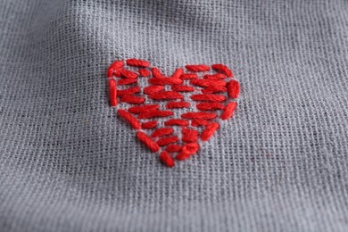 Embroidered red heart on gray cloth, above view