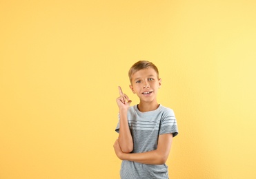 Photo of Adorable little boy in casual clothes on color background