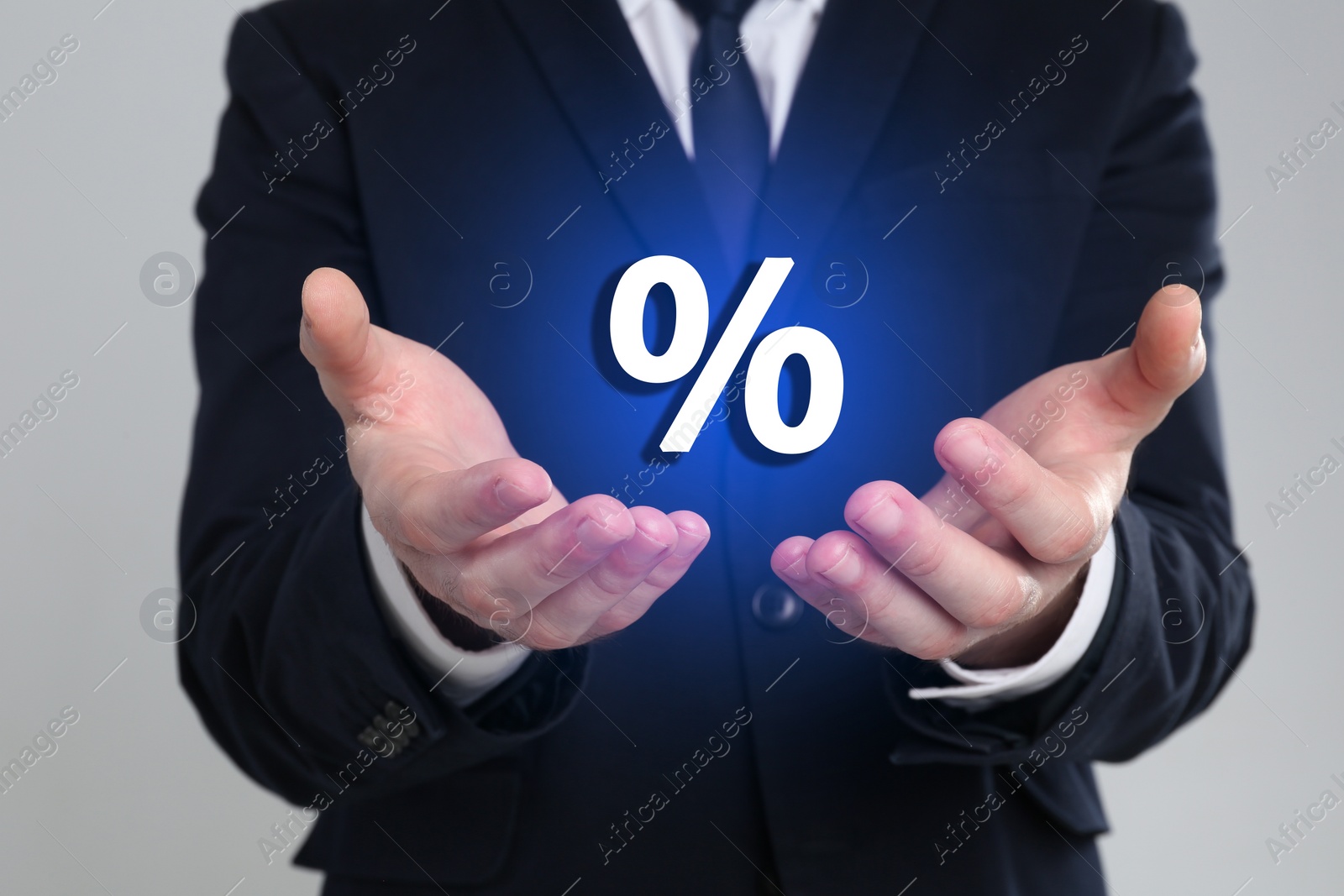 Image of Man showing virtual percent sign on light grey background, closeup. Discount concept