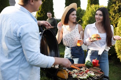Photo of Group of friends having barbecue party outdoors