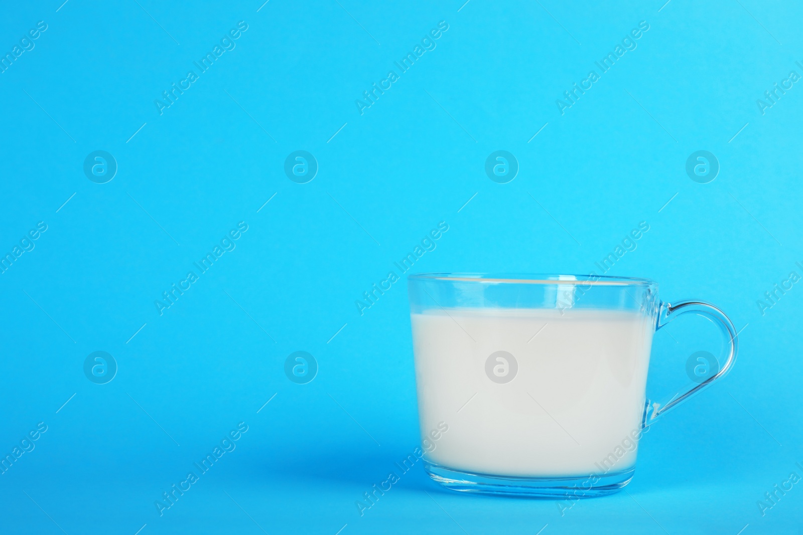 Photo of Glass cup with fresh milk on color background. Space for text