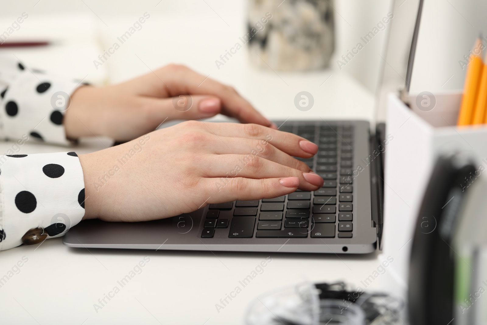 Photo of E-learning. Woman using laptop during online lesson at table indoors, closeup