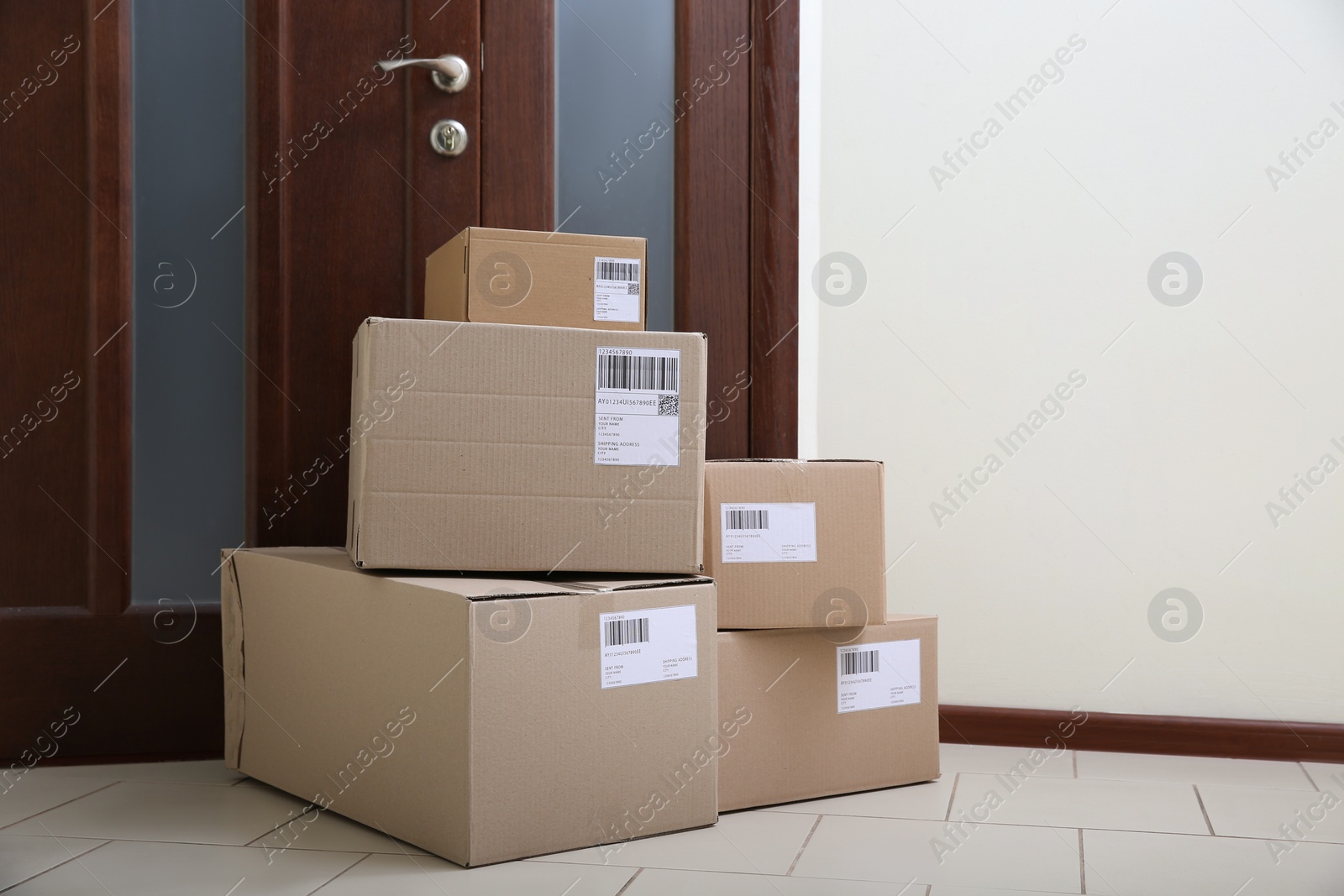 Photo of Stacked parcels near door on floor, space for text. Delivery service