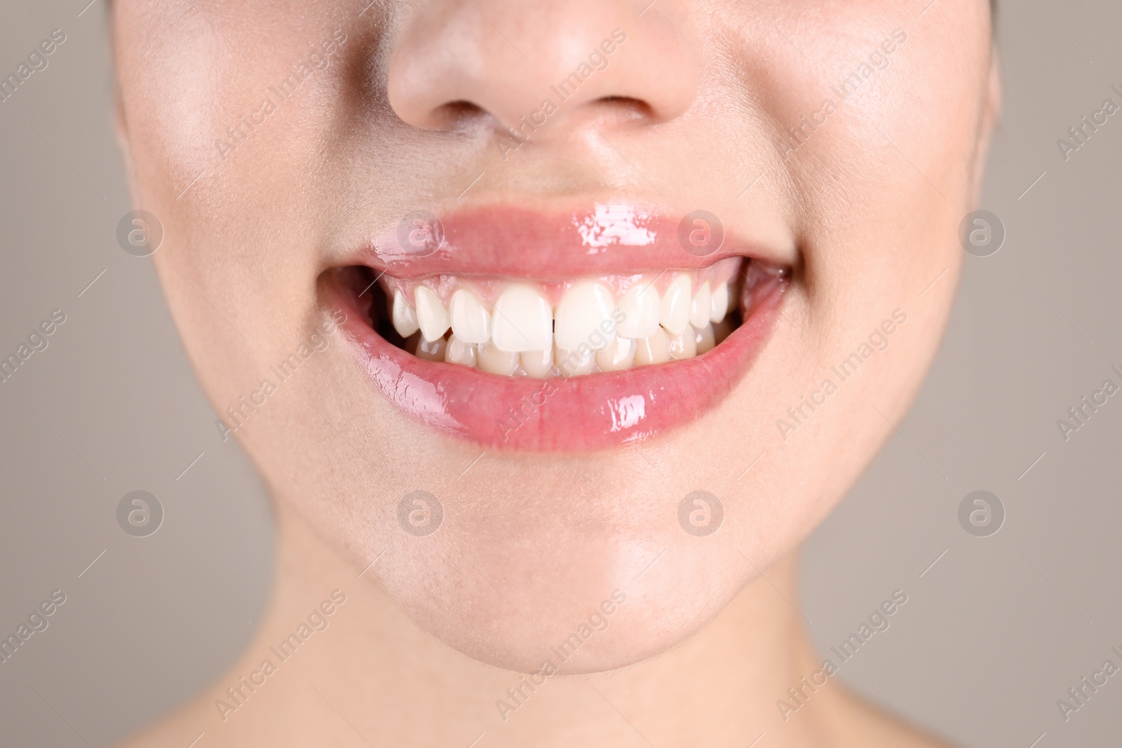 Photo of Beautiful young woman with healthy teeth on color background, closeup