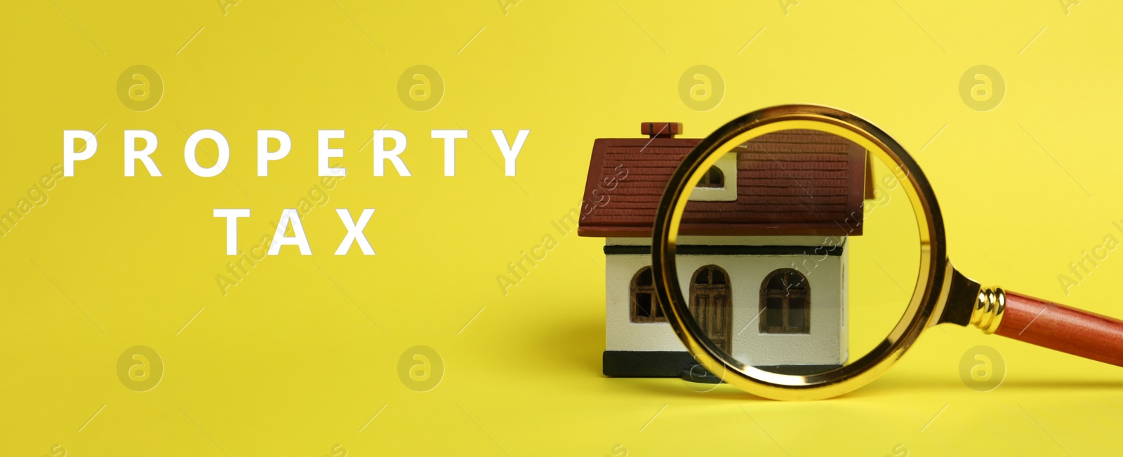 Image of Text Property Tax near magnifying glass and house model on yellow background. Banner design
