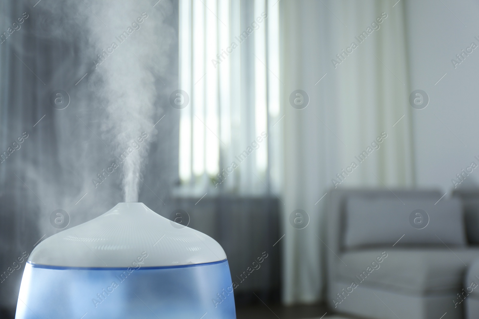 Photo of Modern air humidifier indoors, closeup. Space for text