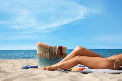 Woman with beach bag on sand near sea, closeup