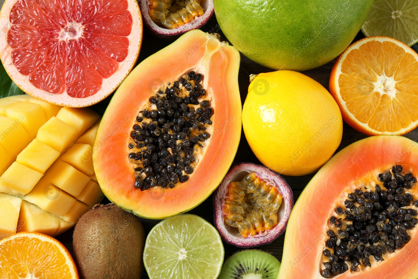 Photo of Fresh ripe papaya and other fruits as background, top view