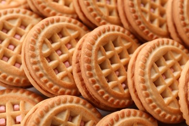 Photo of Tasty sandwich cookies with cream as background, closeup