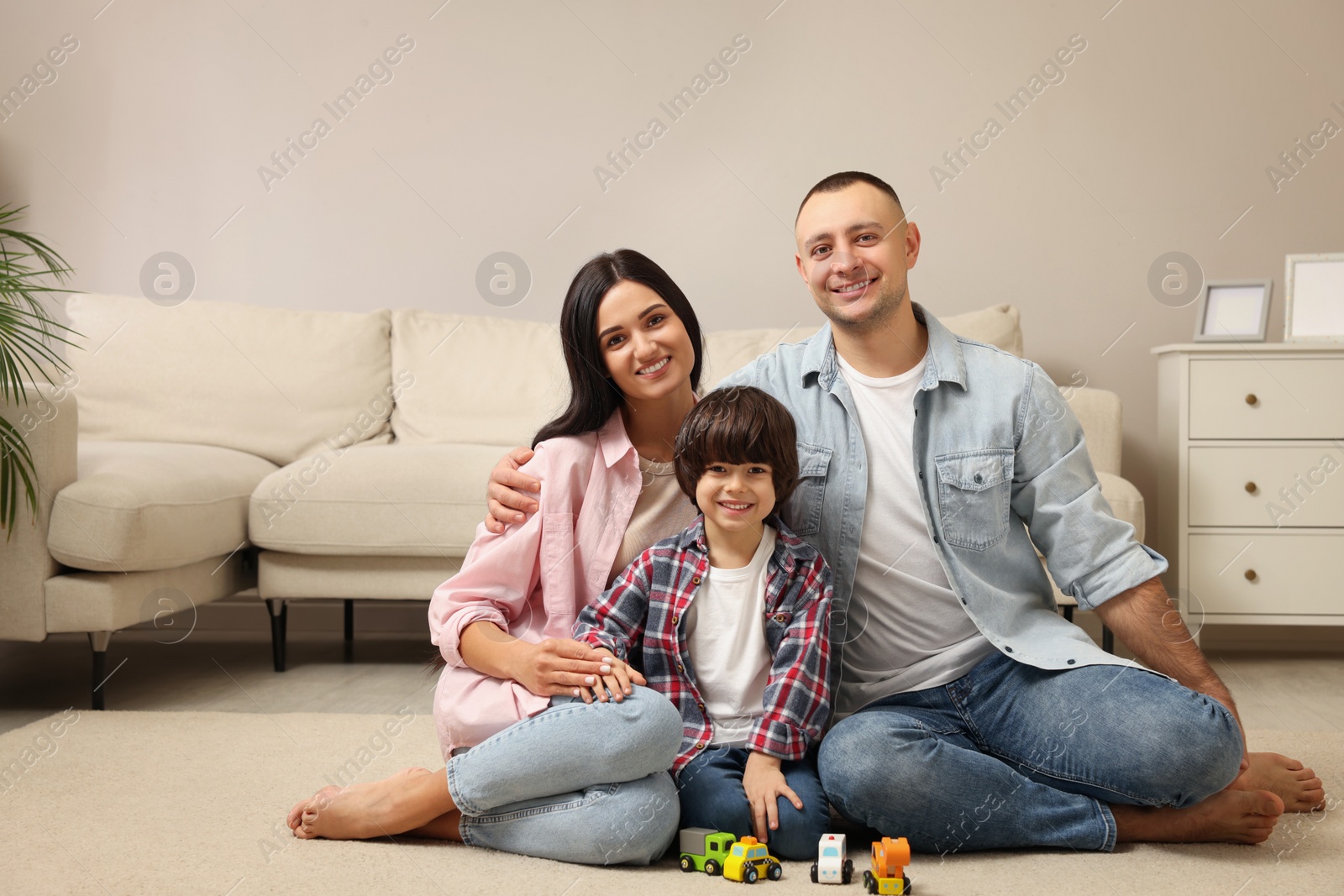 Photo of Happy family sitting on floor at home