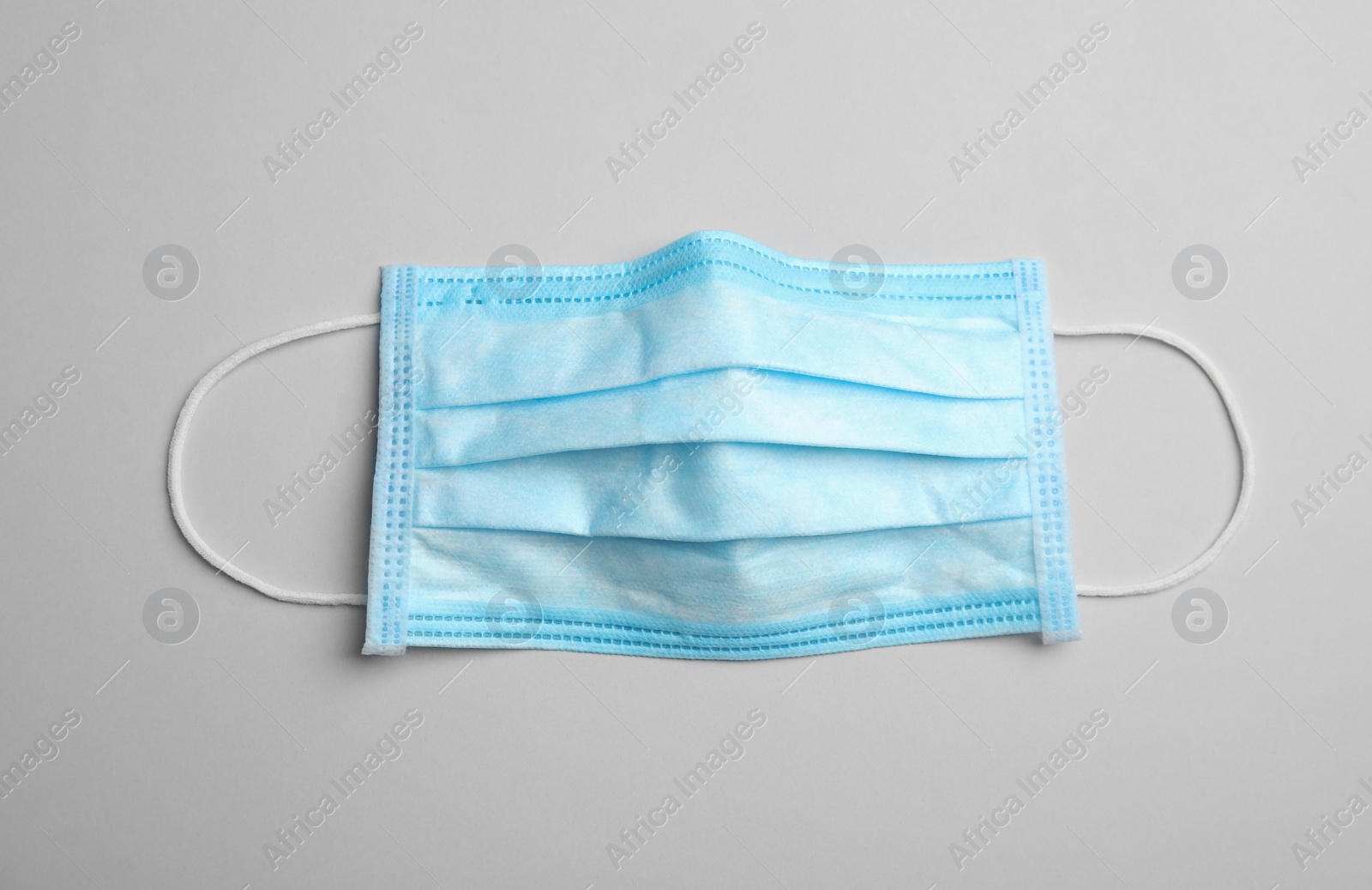 Photo of Medical face mask on grey background, top view