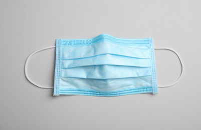 Photo of Medical face mask on grey background, top view