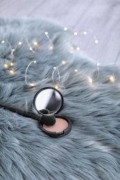 Photo of Makeup brush and powder on faux fur