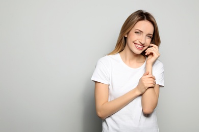 Portrait of young woman with beautiful face on grey background. Space for text