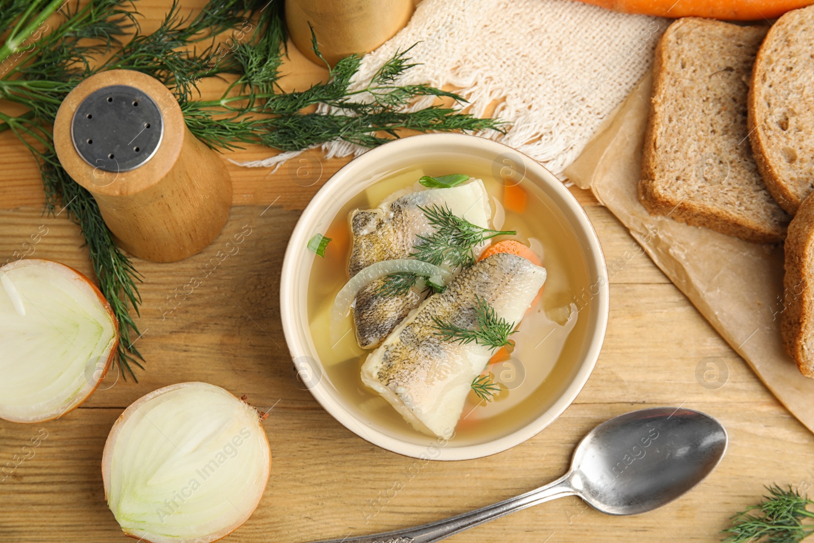 Photo of Delicious fish soup served on wooden table, flat lay