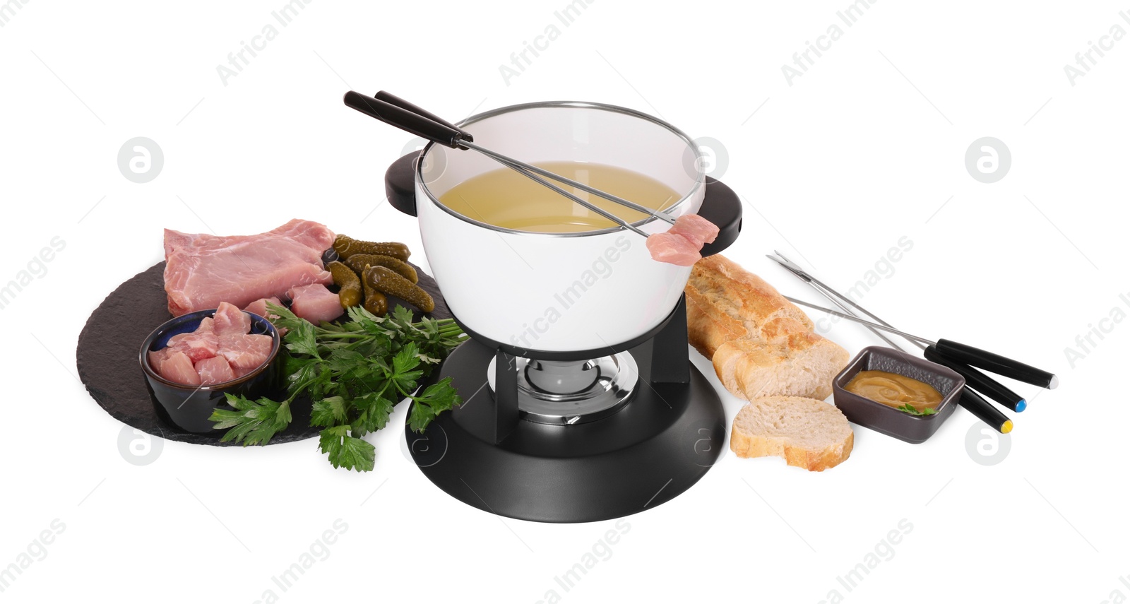 Photo of Oil in fondue pot, forks, sauce, pieces of raw meat and other products isolated on white