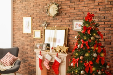 Photo of Room interior with beautiful Christmas tree near decorative fireplace