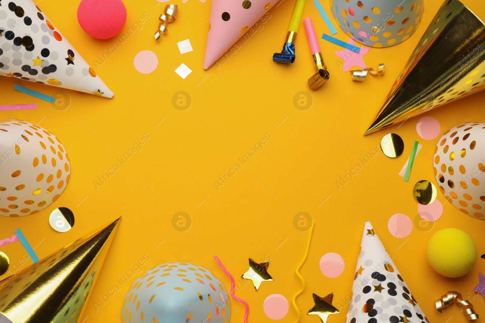 Photo of Flat lay composition with party hats and other festive items on orange background. Space for text