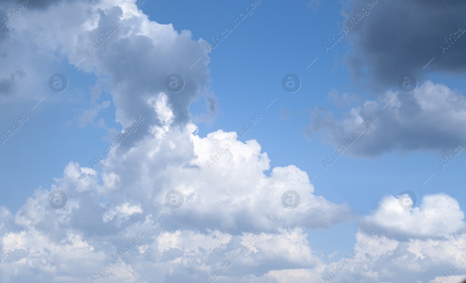 Photo of Beautiful fluffy clouds on light blue sky as background