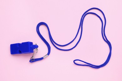 Photo of One blue whistle with cord on pink background, top view