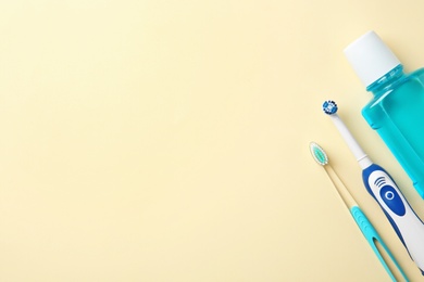 Photo of Flat lay composition with mouthwash, manual and electric toothbrushes on color background