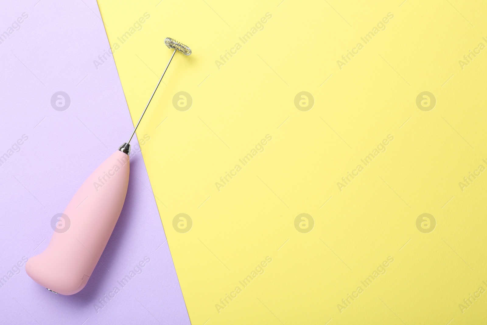 Photo of Pink milk frother wand on color background, top view. Space for text