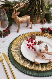 Photo of Luxury festive place setting with beautiful decor for Christmas dinner on white table, closeup