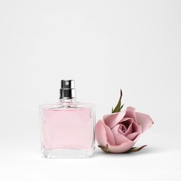 Photo of Transparent bottle of perfume with beautiful flower on white background