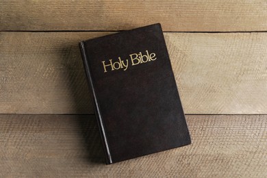 Holy Bible on wooden table, top view