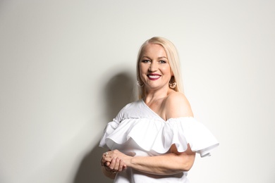 Portrait of beautiful mature woman on light background